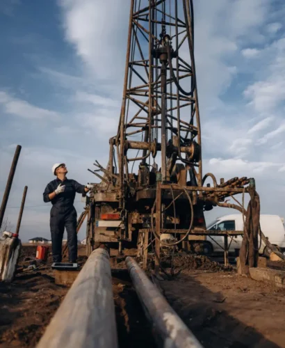 Construction worker is near boring drilling machine.