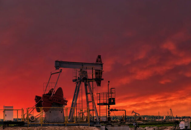 Oil drill rig and pump jack at sunset background. Oil production from ground. Drilling rigs at oilfield in desert. Natural resources, gas. Oil crisis, petroleum industry.